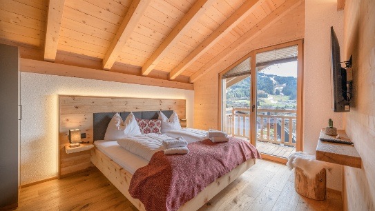 Schlafzimmer in nat&uuml;rlichem Zirbenholz mit Bergblick