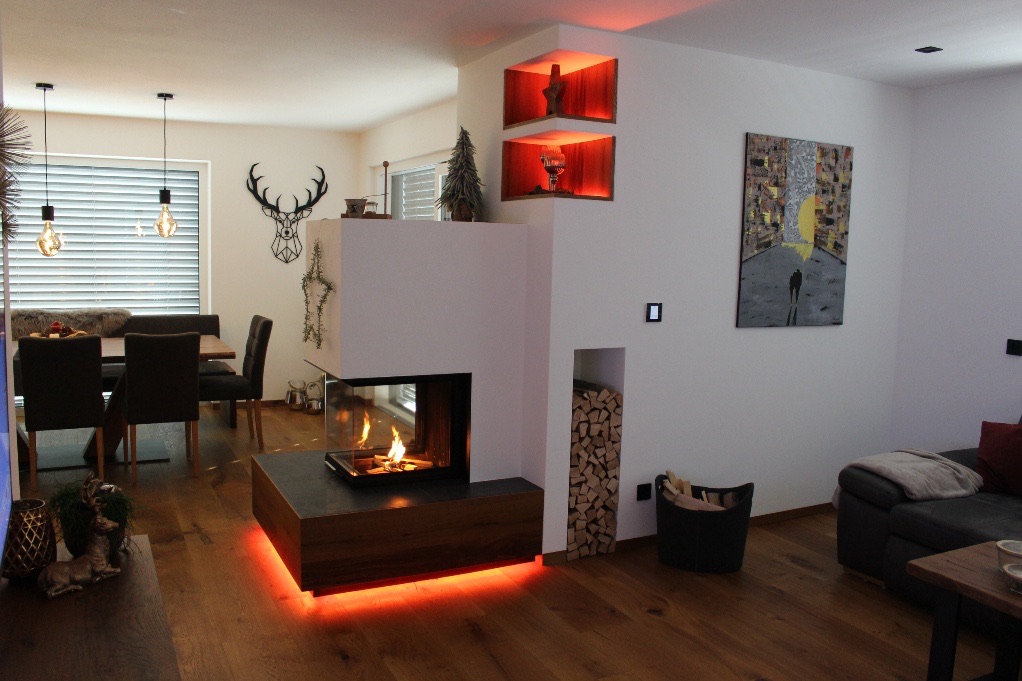 Wohnzimmer mit Kamin und warmen Holzelementen